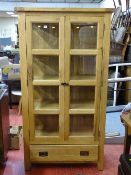 Modern oak twin door glazed display cabinet with lower single drawer