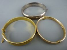 Nine carat gold hollow twist bangle, a silver half bright cut bangle and a yellow metal star
