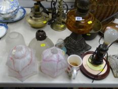 Two vintage oil lamps with glass reservoirs on cast iron bases, a bakelite Art Deco example and a