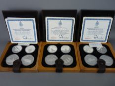 Three 1976 Montreal Olympics silver coin proof sets in leather and wooden display cases