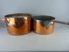TWO LARGE ANTIQUE COPPER PANS, a twin handled example 20.5 cms high, 33 cms diameter and an iron