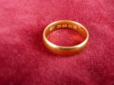 A TWENTY TWO CARAT GOLD WIDE WEDDING BAND, 6 grms