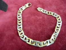 A NINE CARAT GOLD FLAT CURB WHITE & YELLOW BRACELET, 17.3 grms