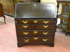 AN ANTIQUE OAK FALL FRONT BUREAU with sliding well interior below an arrangement of pigeonholes