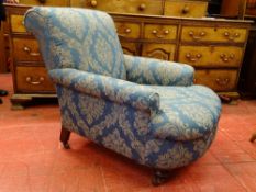 A CIRCA 1900 RE-UPHOLSTERED ARMCHAIR on turned front supports with brown pot castors, 83 cms high,