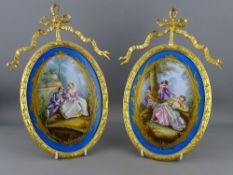 A PAIR OF SEVRES STYLE PLAQUES in gilded ormolu mounts, impressed 230 to the backs, the mounts