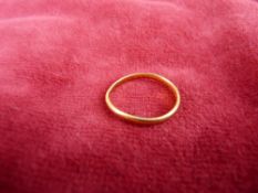 A TWENTY TWO CARAT GOLD NARROW WEDDING BAND 1.6 grms
