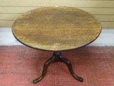 AN ANTIQUE OAK CIRCULAR TILT TOP TRIPOD TABLE, 70 cms high, 90 cms diameter the top