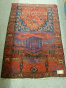 A BALUCHI PRAYER RUG, red and blue ground with architectural and floral pattern, 135 x 91 cms