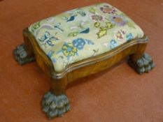 A GOOD WALNUT GEORGE III STYLE FOOTSTOOL, the needlework pad in a shaped frame raised on hairy paw
