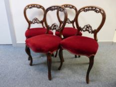 A CLEAN SET OF FOUR VICTORIAN CARVED WALNUT SALON CHAIRS with stuffover upholstered seats