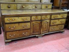 A GEORGE III OAK & CROSSBANDED MAHOGANY LANCASHIRE DRESSER BASE, having a central two drawer and two