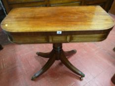 A REGENCY MAHOGANY FOLDOVER CARD TABLE with baize lined interior and swivel top on a turned column