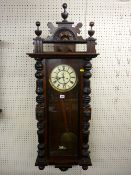 A WALNUT CASED TWIN WEIGHT PENDULUM DRIVEN VIENNA WALL CLOCK with lion mask carving, 127 x 42 cms