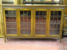 AN EXCELLENT FOUR DOOR OAK BOOKCASE of slim proportions with adjustable interior shelves and