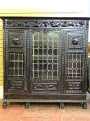 A 19th CENTURY HEAVILY CARVED & EBONIZED NORTHERN EUROPEAN CABINET with figural and mask