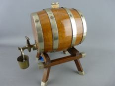 AN OAK SPIRIT BARREL ON STAND with plated mounts, barrel tap and bucket, 25 cms high, 23 cms long