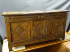 AN ANTIQUE OAK BLANKET CHEST of pegjoined construction having triple panel lift-up lid and front,