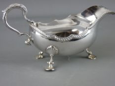 A SILVER SAUCE BOAT with scroll handle on three shell feet, London 1970, 12.4 troy ozs, 21.5 cms