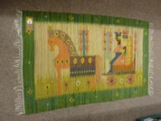 A MOROCCAN KILIM RUG, green bordered with tassel ends and central pictorial pattern of nobles in a
