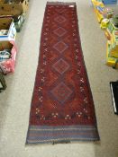 A MESHWANI CARPET RUNNER, red ground with repeating central diamond pattern and continuous border,