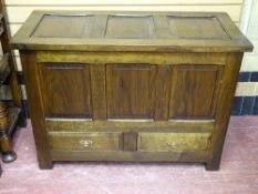 A GOOD REPRODUCTION OAK MULE CHEST with panel lidded top and front over twin lower drawers, on stile