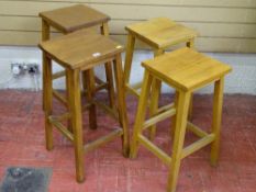 A SET OF FOUR VINTAGE LABORATORY STOOLS, two 68 cms high, two 62 cms high