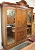 An Edwardian mahogany triple wardrobe together with a dressing table and bed