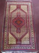 A Persian Wool Burgundy and White Carpet.