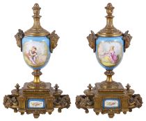 A pair of Sevres style porcelain and gilt metal urns
