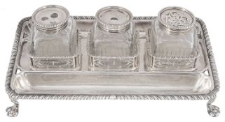A Georgian silver deskstand with associated glass silver topped bottles, hallmarked London, with mak