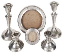 Two pairs of silver candlesticks and silver photograph frames