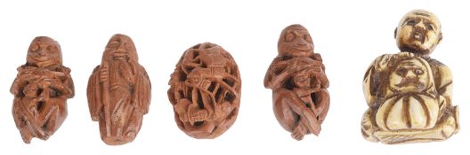 A small late 19th century Japanese carved netsuke and four coquilla nut carvings