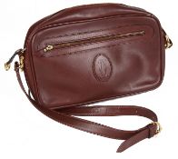 A Cartier burgundy leather messenger bag, with dust bag