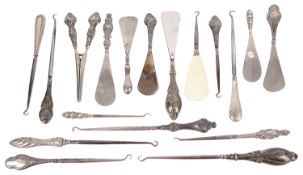 A collection of Victorian and later silver handled button and boot hooks, shoe horns