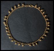 A hallmarked 9ct gold ankle bracelet having ball f