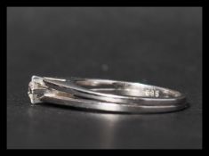 A 14ct white gold and diamond solitaire ring. The