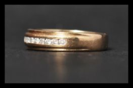 A hallmarked 9ct gold and diamond band ring set wi