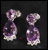 A pair of sterling silver and amethyst drop earrin