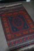 A Persian Islamic floor rug having a deep red and