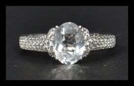 A 14ct white gold ring having a large central faceted white sapphire with white sapphire