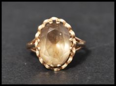 A hallmarked 9ct gold and smokey quartz dress ring set with a large oval cut smokey quartz in a