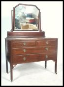 A vintage 20th century mahogany dressing table, fitted swing mirror over an arrangement of