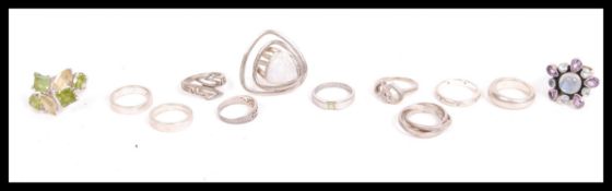 A dealers lot of silver to include 12 silver 925 rings. trilogy ring, swirl, contemporary, stone