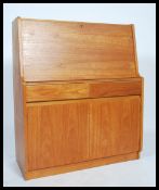 A retro 20th century Danish influence teak wood bureau desk having a fall front with fully appointed