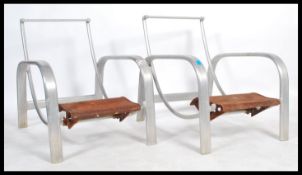 A pair of unusual mid century aluminium lounger chairs / armchairs of swept form having metal foot