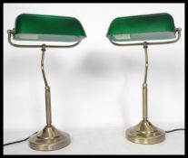 A pair of vintage 20th century bankers desk lamps having green glass shades with adjustable goose