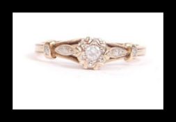 A hallmarked 9ct gold and diamond ring set with a single central diamond and diamond accent