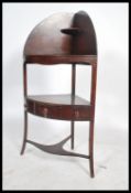 A 19th century Georgian mahogany corner wash stand raised on three splayed legs with recess for wash
