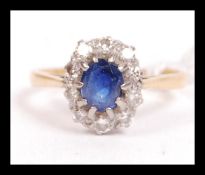 An 18ct gold diamond and sapphire ring. The central sapphire being prong set having a halo of